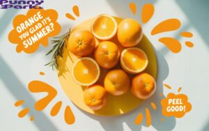 A photo of fresh oranges and orange slices on a light yellow surface. Scattered around the fruit are playful splashes of orange juice, and text bubbles containing phrases like "Orange you glad it's summer?" and "Peel good!".