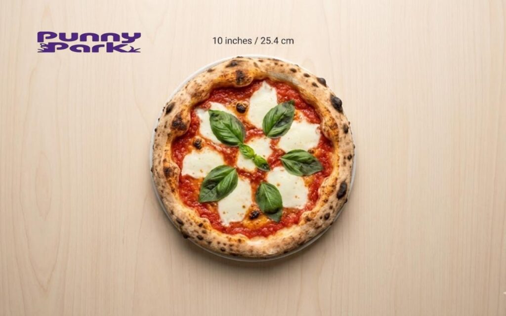 A top-down view of a whole Margherita pizza with fresh basil leaves. Text above the pizza notes a diameter of 10 inches or 25.4 cm.